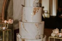 a sophisticated white marble wedding cake with gold leaf, macarons and white blooms is a gorgeous solution for many weddings
