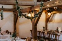 a stylish barn wedding table with white linens, greenery, billy balls, copper touches