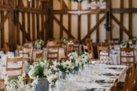 a super elegant barn wedding table with neutral linens, blue vases with white and blue blooms