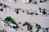 a wedding venue backdrop or just decor with garlands of black and white Polaroids and greenery and lights