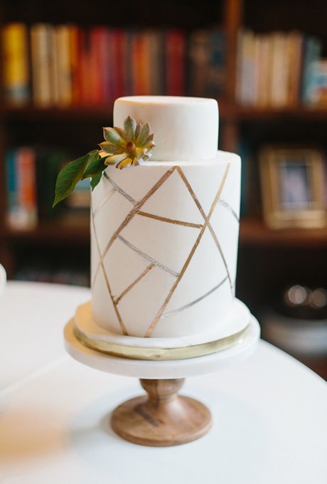 a white and gold geometric wedding cake with sugar blooms is a stylisha nd timeless idea for a modern wedding