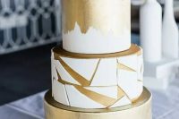 a white and gold wedding cake with brushstrokes and geometric shards plus white shards on top is a very elegant and chic idea