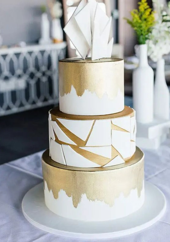 a white and gold wedding cake with brushstrokes and geometric shards plus white shards on top is a very elegant and chic idea