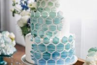 a white round wedding cake with blue and aqua watercolor hexagons covering all the tiers is a very lovely idea