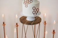 a white round wedding cake with copper hexagons is a stylish and refined idea for a modern wedding with geometric decor