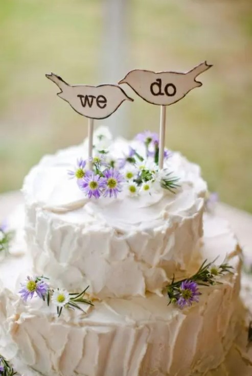 a white textural wedding cake with wildflowers and wood burnt toppers is ideal for many rustic weddings