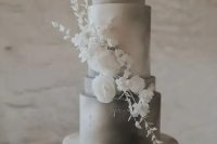 an elegant grey and white watercolor wedding cake with white sugar blooms is a cool and very sophisticated option