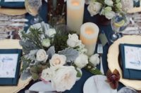 an elegant navy blue and gold wedding tablescape with neutral florals, elegant cutlery