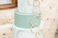 an olive green wedding cake with marble and usual tiers, with gold hexagons covering them is a very beautiful idea