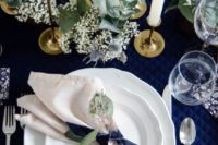 bold navy, cremay and gold wedding tablescape with white blooms and thistles and lots of white candles