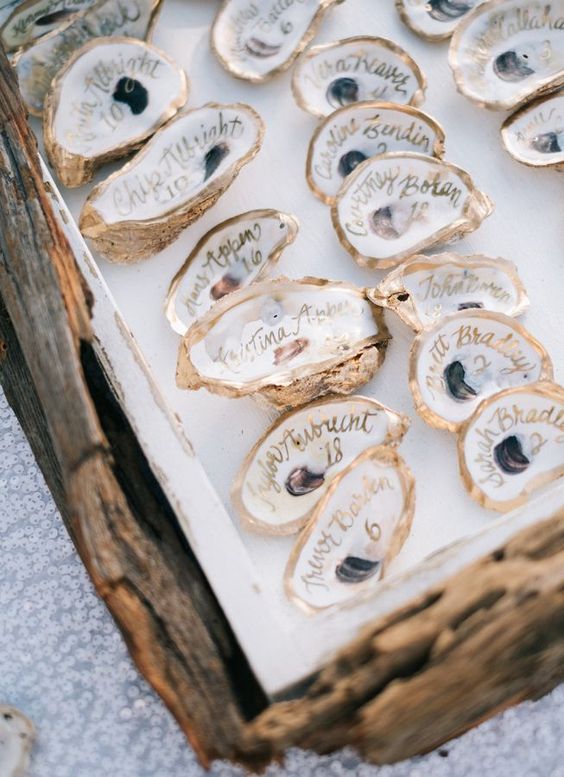 small pretty gilded seashells with names are nice for a beach wedding, you can easily DIY them