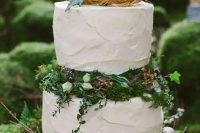 two white buttercream wedding cakes served with moss, succulents and greenery in between plus a faux nest on top