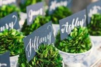 vintage polka dot teacups with fresh greenery and cool chalkboard escort cards can double as favors