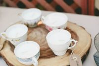 vintage teacups with cardboard escort cards placed on wooden slices are a lovely idea for a rustic wedding