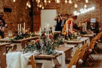 a barn wedding venue decorated with bulbs, greenery and candles on the tables is a lovely and welcoming space to enjoy