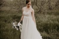 a beautiful and romantic wedding dress with no sleeves, an illusion neckline and a layered tulle skirt with a trian