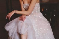 a blush A-line wedding dress with spaghetti straps, a full skirt and star appliques for a celestial bride