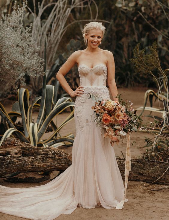 a blush mermaid wedding gown with a strapless sweetheart neckline and a pleated skirt, a train and embroidery and embellishments