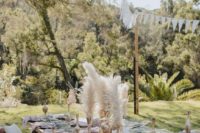 a boho wedding picnic with a cross table, pampas grass, neutral air plants, pastel linens for a spring celebration