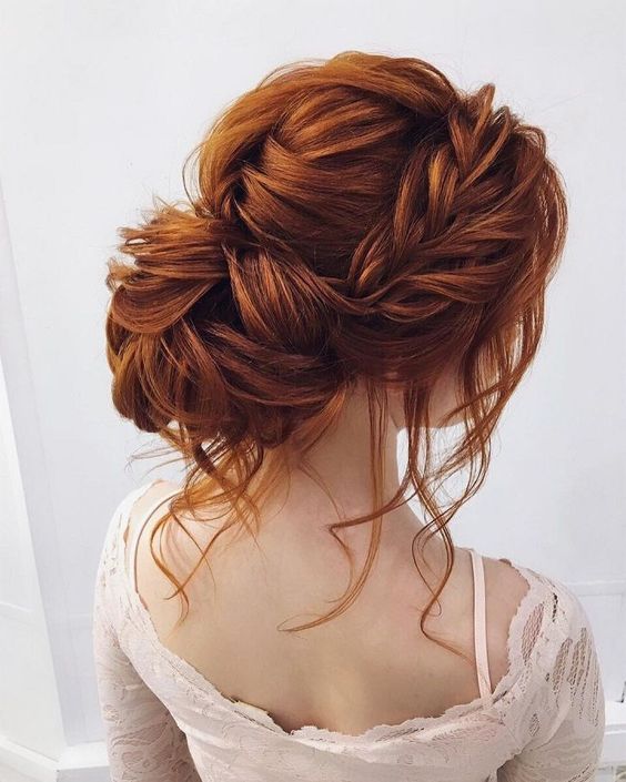 a bold and chic wavy low updo with a double braided halo, some locks down and a braided and twisted top