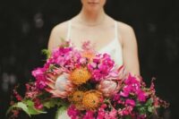 a bold wedding bouquet of hot pink blooms, pincushion and king proteas, greenery with a cascading shape