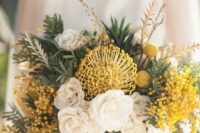 a bold wedding bouquet of white roses, pincushion proteas, billy balls and mimosas, greenery is a cool idea for spring or summer