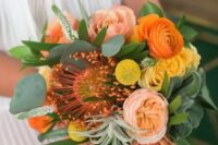 a bold wedding bouquet with orange and yellow ranunculus, a pincushion protea, coral peony roses, billy balls, greenery and air plants