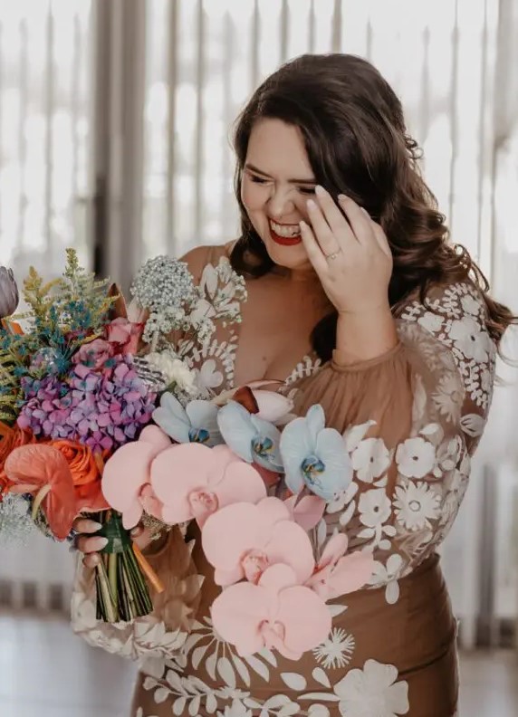 a bride rocking a fantastic iridescent statement wedding bouquet with colorful blooms, foliage and grasses for a wow factor
