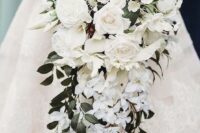 a cascading wedding bouquet with peonies, small and large roses and foliage looks refined and luxurious