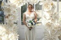 a catchy wedding arch made of white oversized paper blooms is a cool idea for an eco-conscious wedding