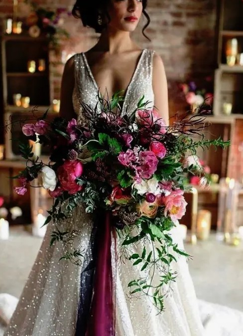 a colorful and lush winter wedding bouquet in pink, purple, with much greenery and texture for a colorful NYE wedding