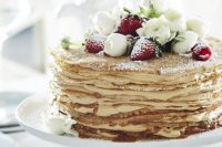 a crepe wedding cake with cream cheese, fresh berries and decorated with white ranunculus is a lovely idea for summer