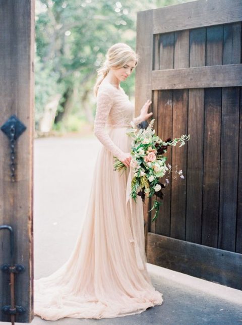 a cute blush wedding gown with a lace bodice and long sleeves and a draped skirt for an ethereal romantic look