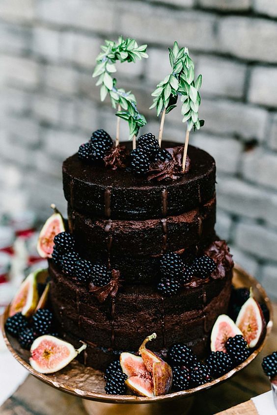 a delicious naked chocolate wedding cake topped with fresh figs and blackberries, with greenery monograms is a gorgeous idea to rock