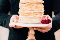 a gorgeous crepe wedding cake topped with pink and red roses is a lovely idea for a modern wedding, especially for a Valentine’s Day wedding