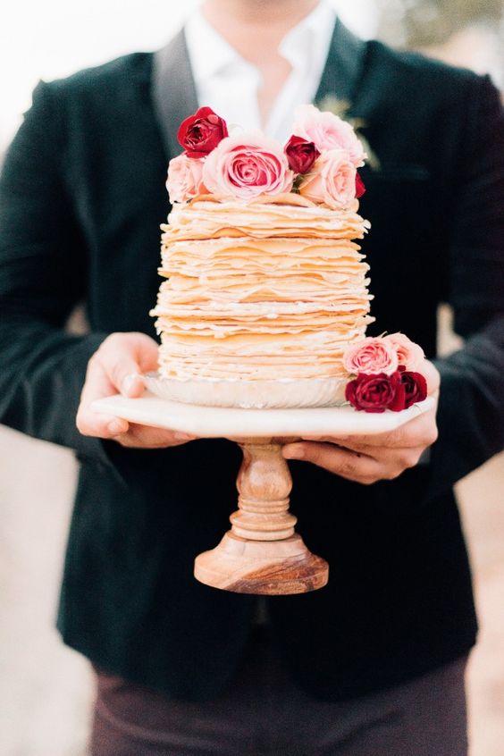 a gorgeous crepe wedding cake topped with pink and red roses is a lovely idea for a modern wedding, especially for a Valentine's Day wedding