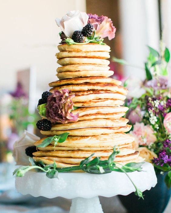 a lovely pancake wedding cake topped with fresh blackberries, white and dusty pink blooms and greenery is amazing