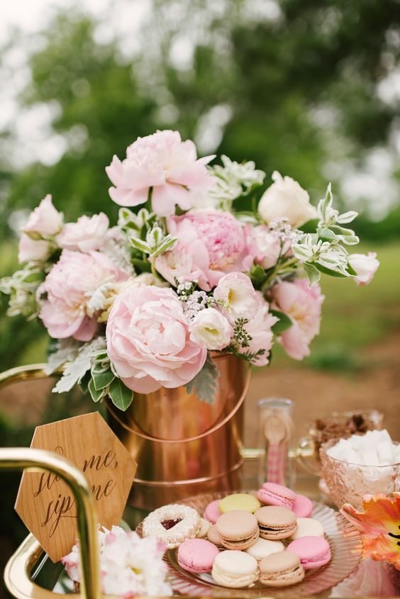 a lovely pink peony centerpiece with foliage in a copper bucket and some pretty pink and neutral sweets for a gardne bridal shower