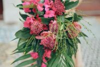 a lush cascading wedding bouquet with much greenery and pink flowers of various kinds