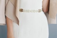 a modern plain fitting wedding dress with a gold and white opal sash that accents the waist and adds interest to the look