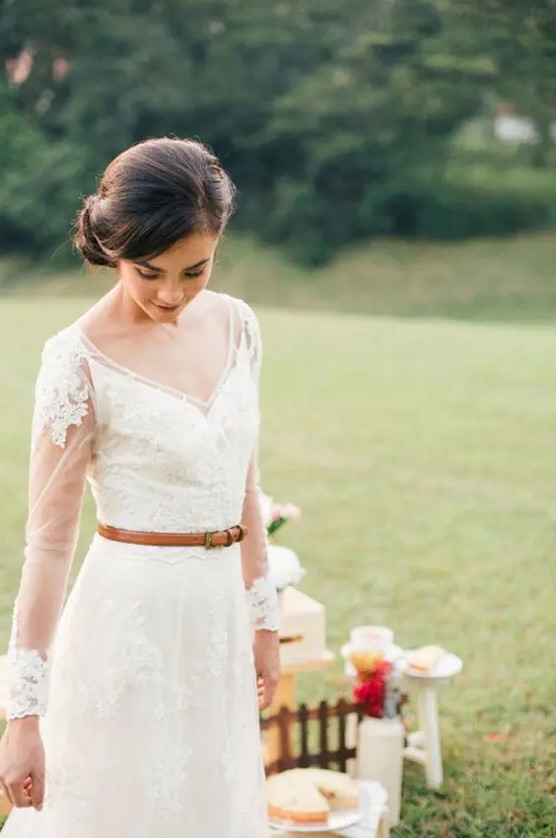 a modest and cute wedding dress with illusion sleeves and an amber leather belt for a rustic touch