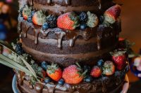 a naked chocolate wedding cake with chocolate drip, fresh berries and greenery is a gorgeous and delicious idea for any relaxed and laid-back wedding