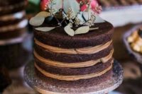 a naked chocolate wedding cake with greenery on top is a lovely idea for a relaxed wedding, in any season