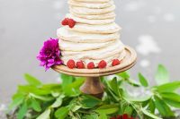 a pancake wedding cake with cream cheese, raspberries and bold purple blooms is a lovely idea for summer