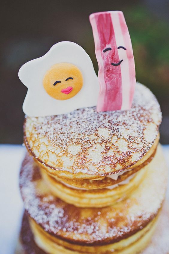 a pancake wedding cake with sugar powder topped with a candy fried egg and a slice of bacon is amazing for a brunch wedding