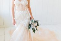 a pastel strapless mermaid wedding dress with white lace appliques, a train and a corset for a sexy and chic bridal look