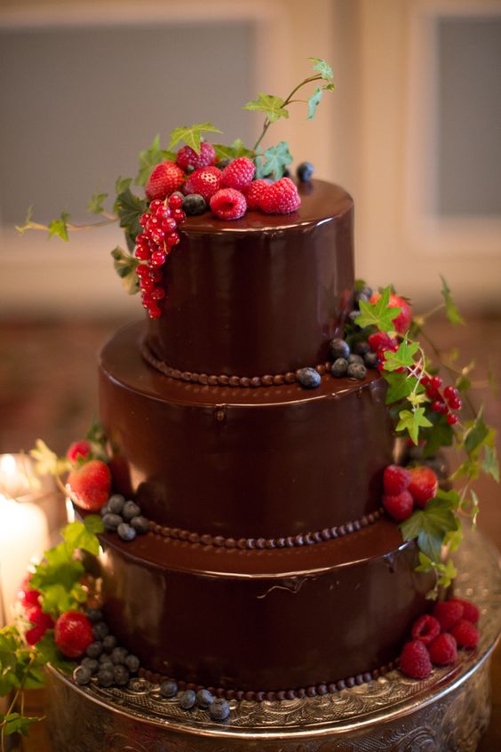 a refined chocolate wedding cake with chocolate beads, fresh berries and greenery is a gorgeous idea for a summer or fall wedding