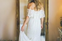 a simple boho lace off the shoulder wedding dress with a short train for a summer boho barn bride