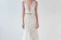 a sophisticated boho lace mermaid wedding dress with a plunging neckline and no sleeves plus a train and a shiny gold metallic belt