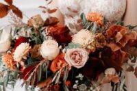 a sophisticated fall wedding bouquet with burnt orange, orange, blush and neutral blooms, berries and textural greenery, dark foliage